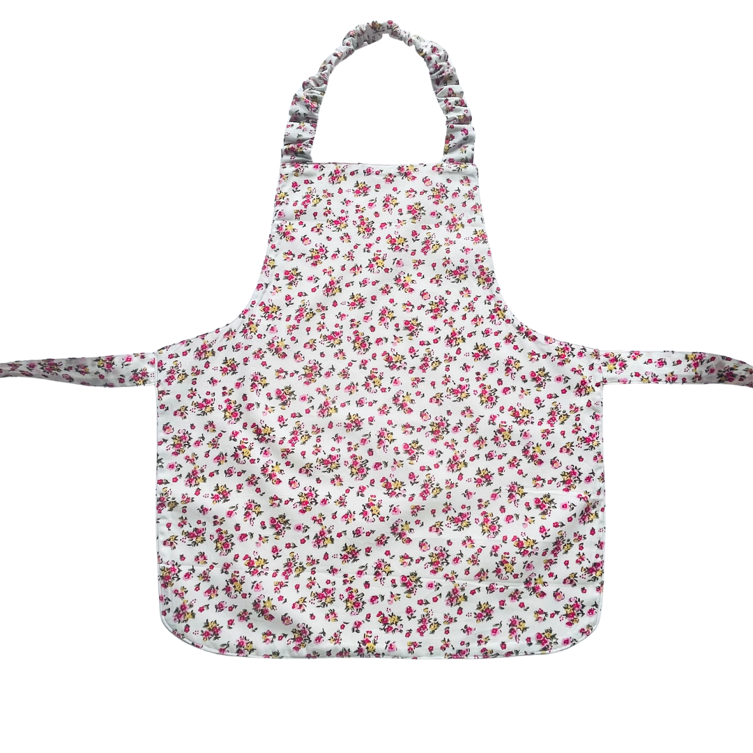 A toddlers apron and matching oven mitt set. Pattern is white with pink and yellow dainty flowers all over.