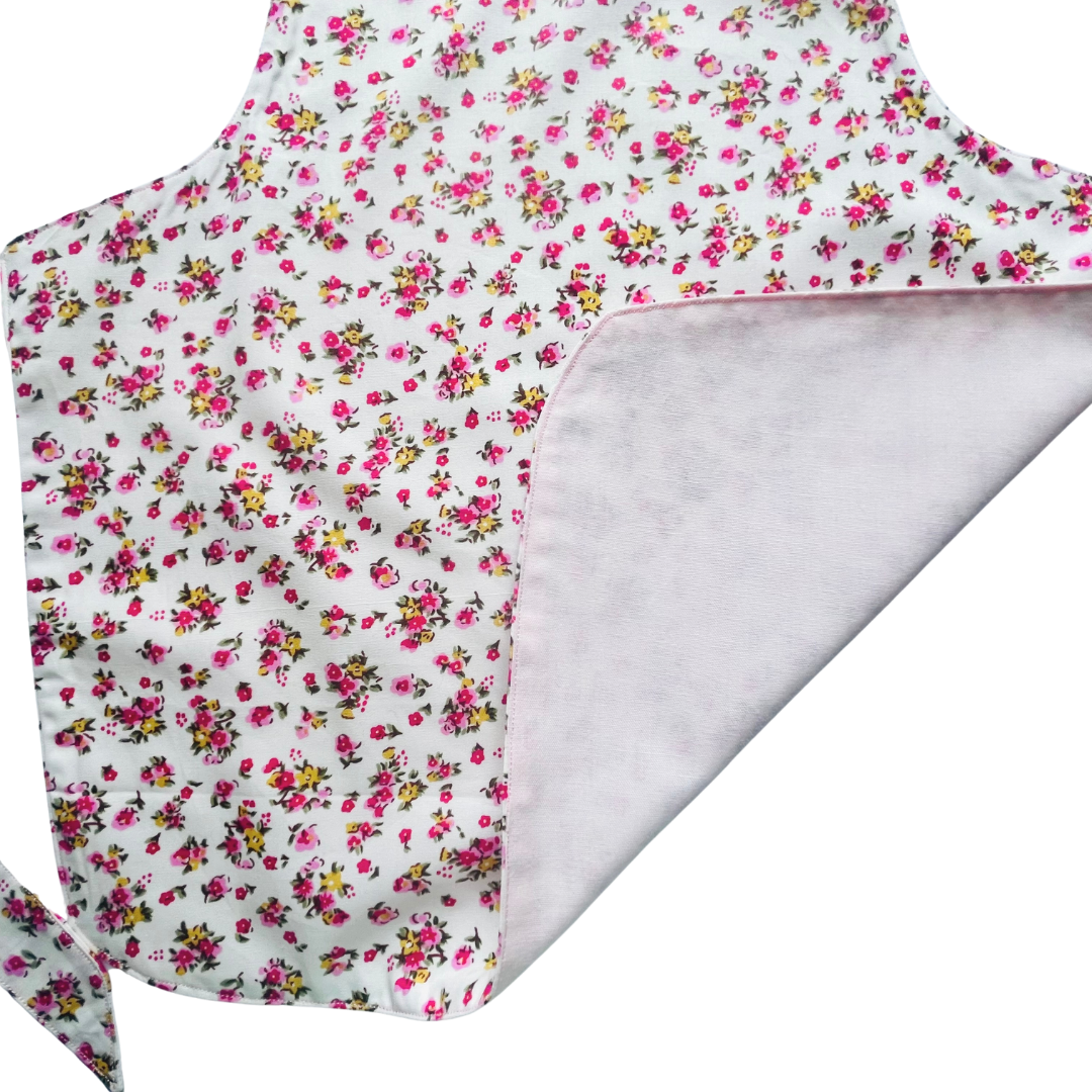A toddlers apron and matching oven mitt set. Pattern is white with pink and yellow dainty flowers all over.
