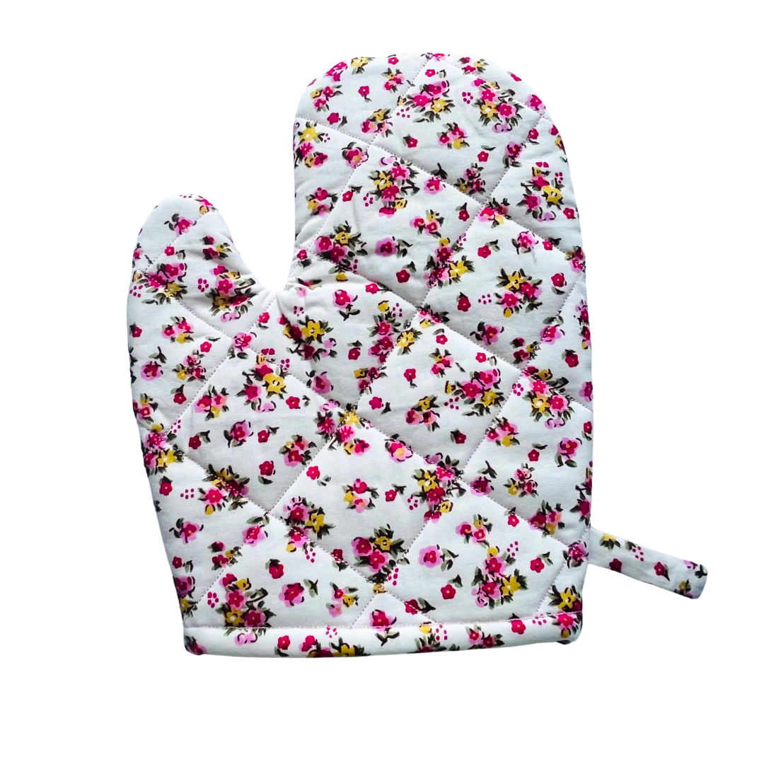 A toddlers apron and matching oven mitt set. Pattern is white with pink and yellow dainty flowers all over.