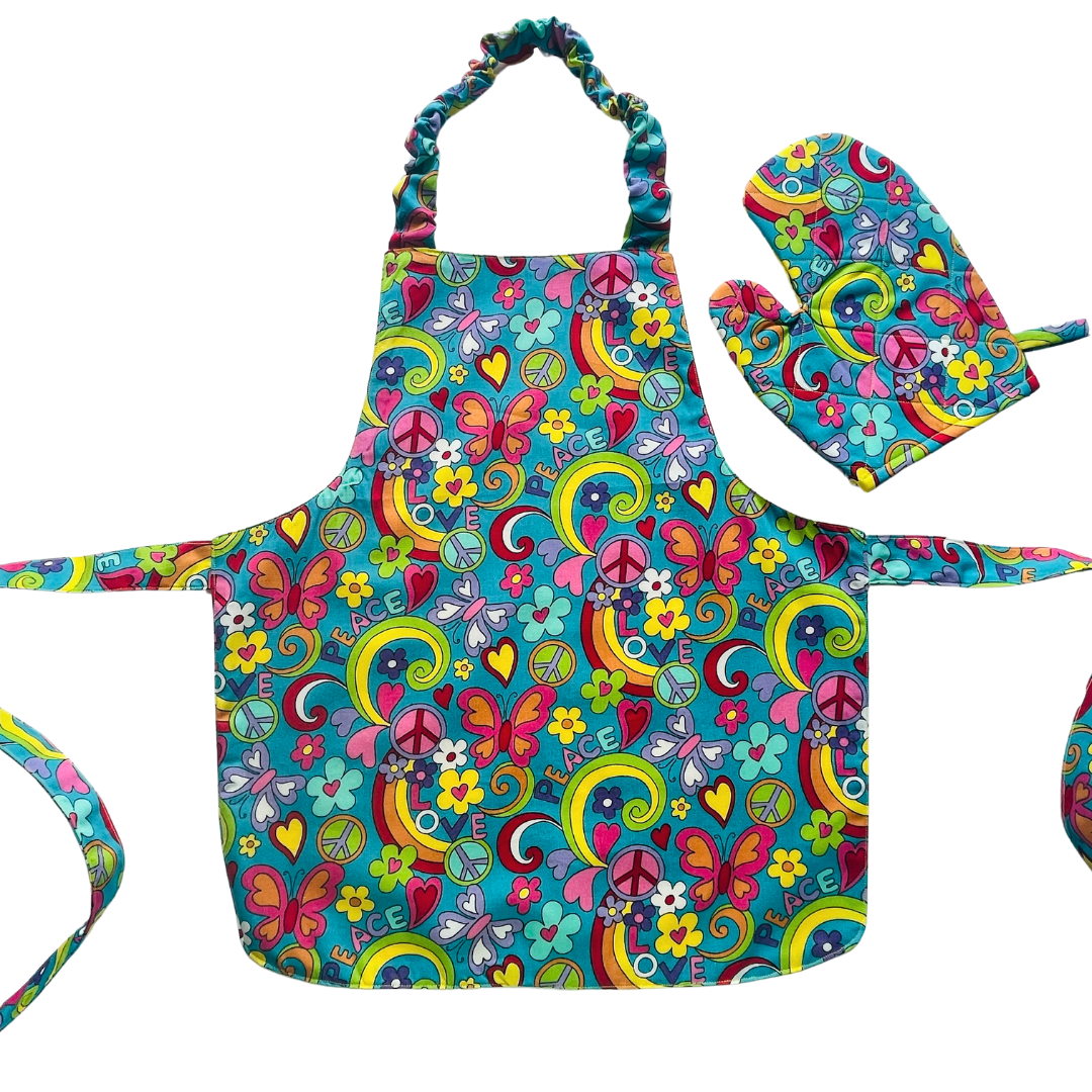 A child’s apron and matching oven mitt set. Pattern is turquoise with brightly coloured 60s inspired funky pictures all over.
