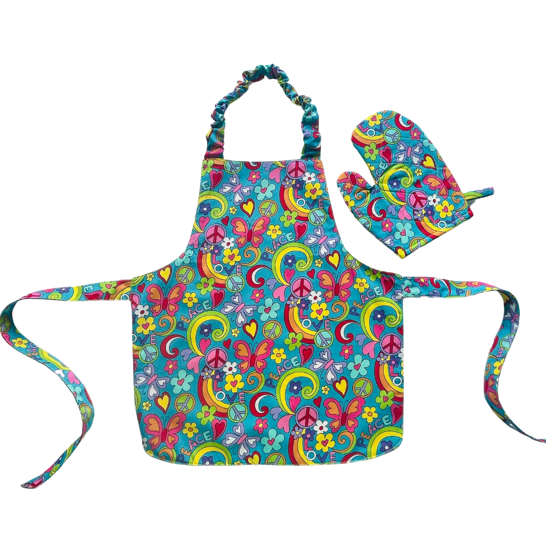 A child’s apron and matching oven mitt set. Pattern is turquoise with brightly coloured 60s inspired funky pictures all over.