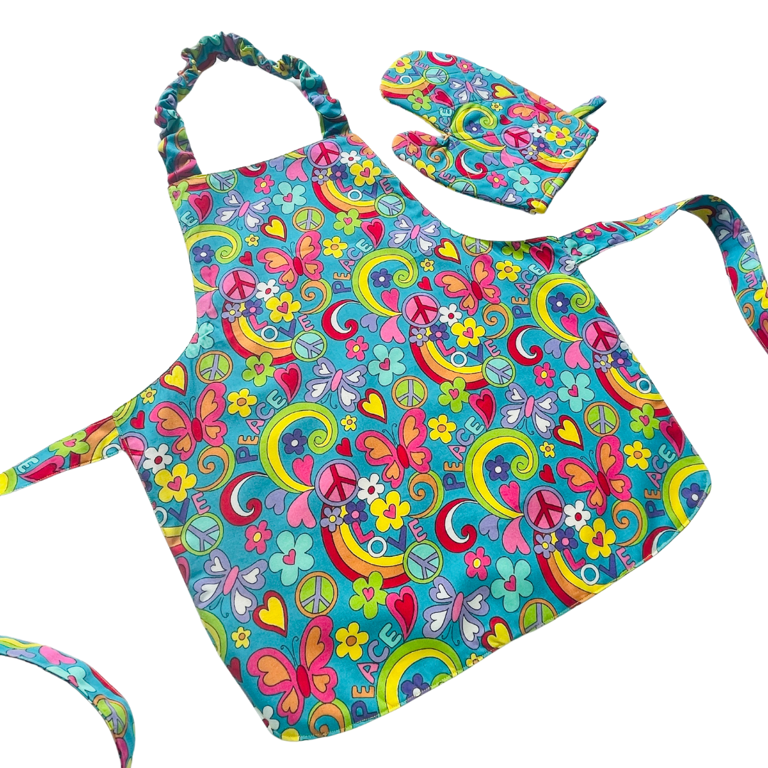 A child’s apron and matching oven mitt set. Pattern is turquoise with brightly coloured 60s inspired funky pictures all over.