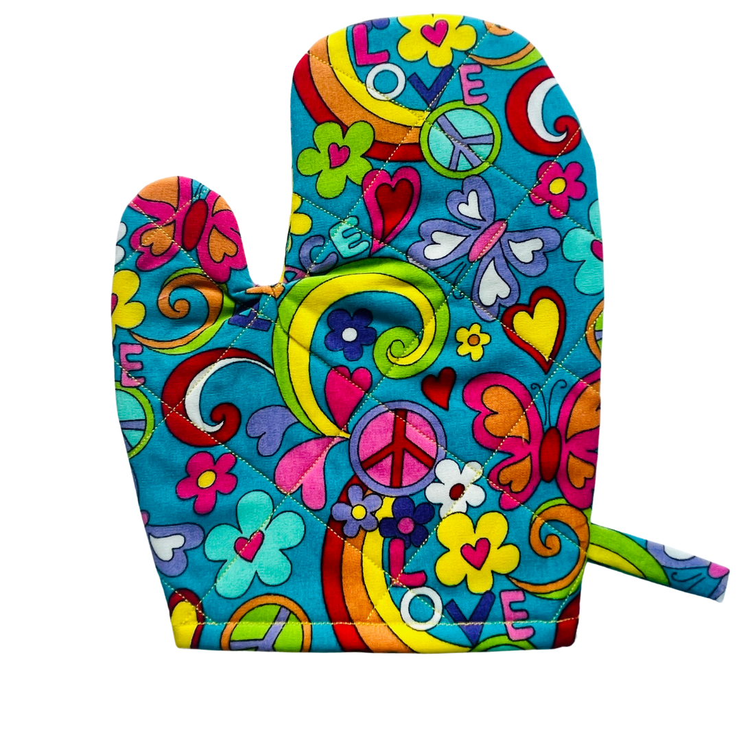 A child’s apron and matching oven mitt set. Pattern is turquoise with brightly coloured 60s inspired funky pictures all over.