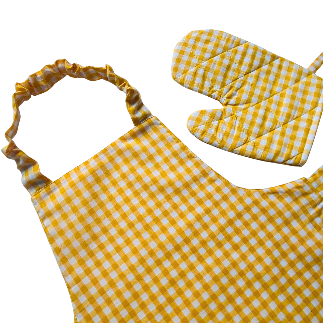 A child’s apron and matching oven mitt set. Pattern is yellow and white gingham.