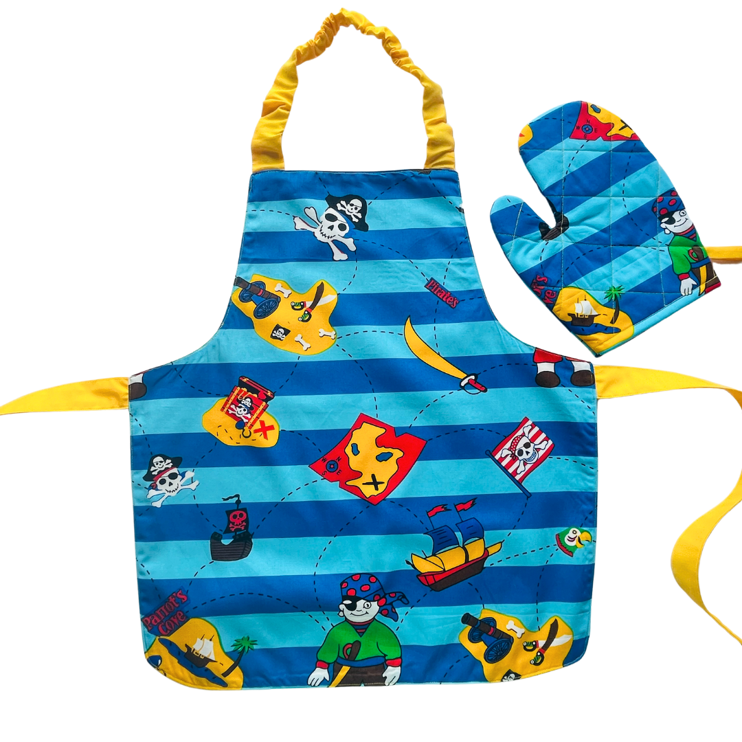 A child’s apron and matching oven mitt set. Pattern is light and dark blue with yellow and has pirate pictures such as treasure, maps and ships all over.