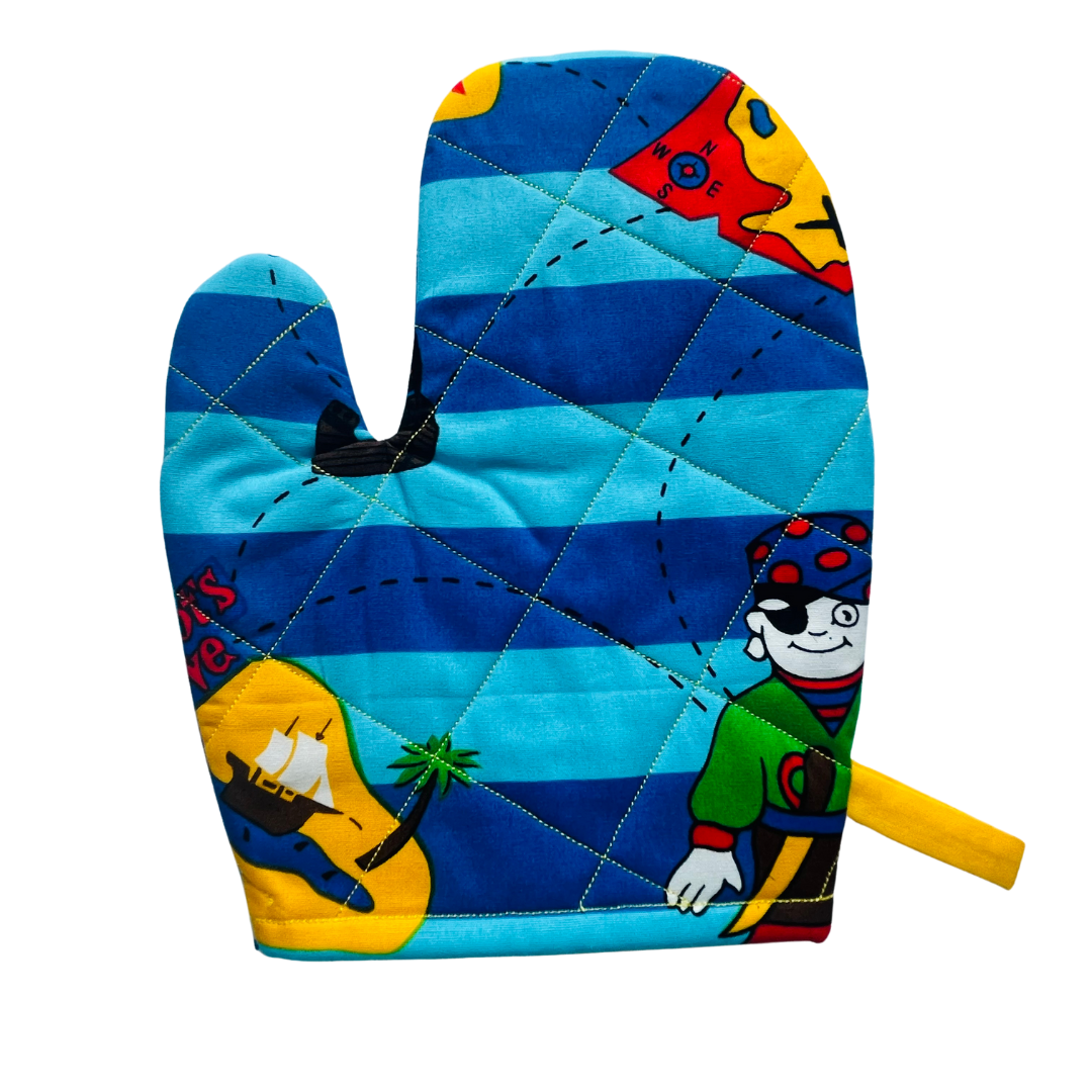 A child’s apron and matching oven mitt set. Pattern is light and dark blue with yellow and has pirate pictures such as treasure, maps and ships all over.