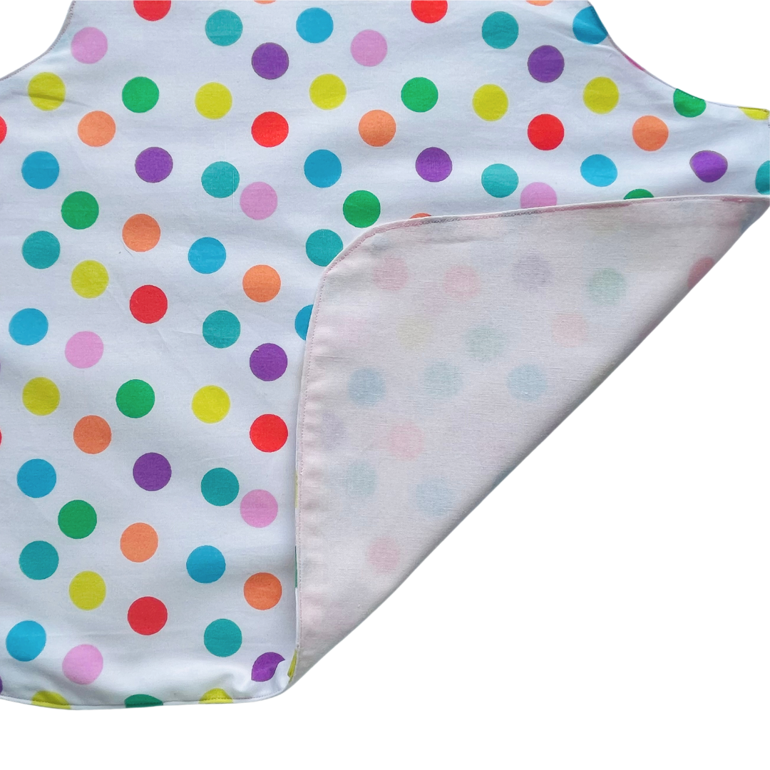 A child’s apron and matching oven mitt set. Pattern is white and pale pink and has multicoloured spots all over.