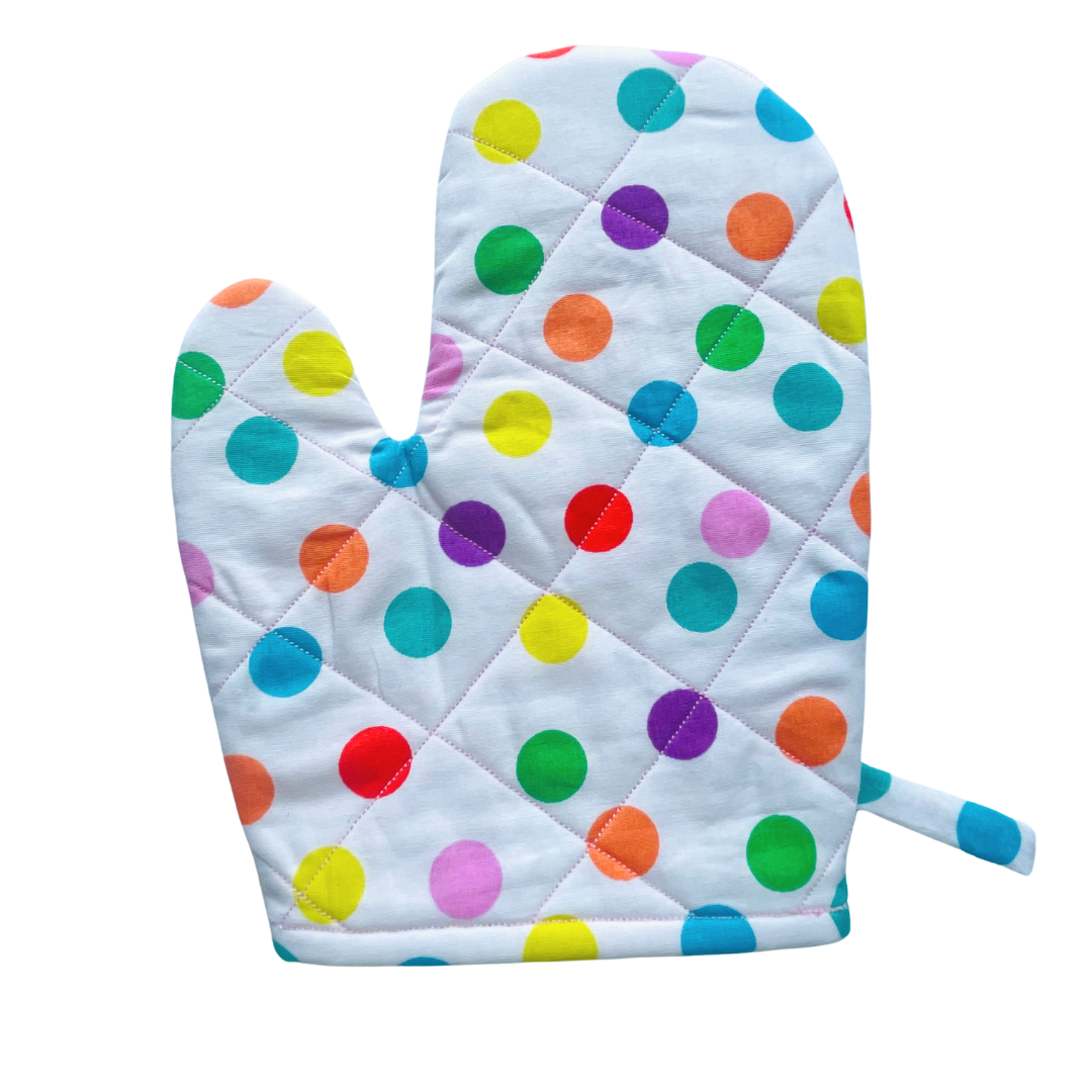A child’s apron and matching oven mitt set. Pattern is white and pale pink and has multicoloured spots all over.