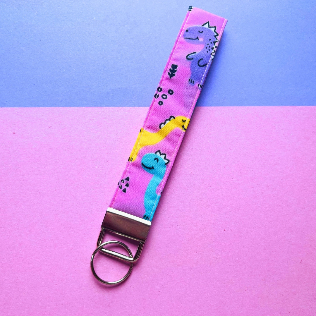 Key fob wristlet with a pink dinosaur print