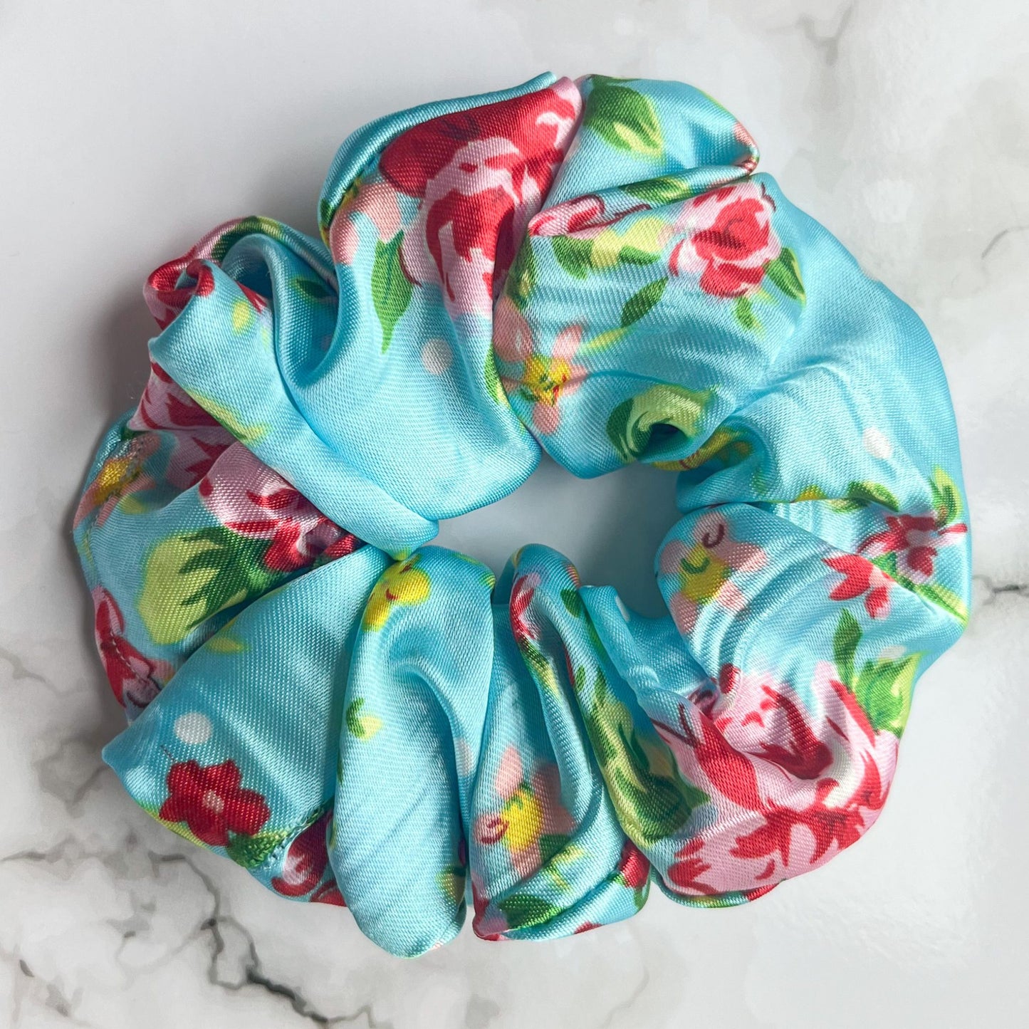 Close up of blue floral hair scrunchie satin E for Eva