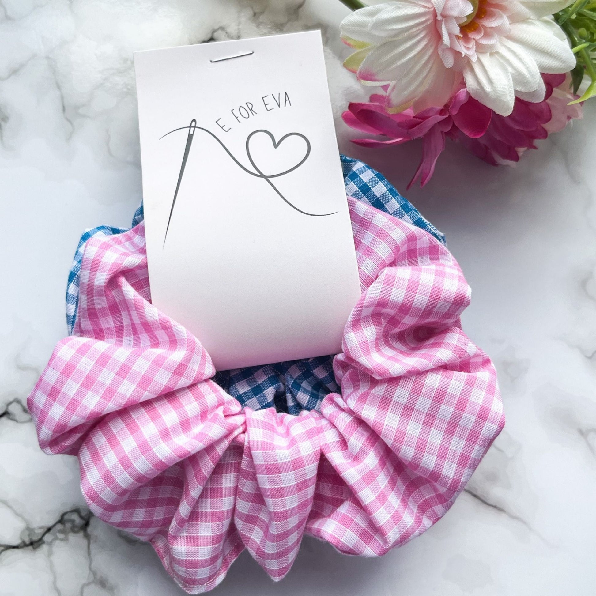 Styled tagged view of pink and blue gingham hair scrunchies cotton E for Eva