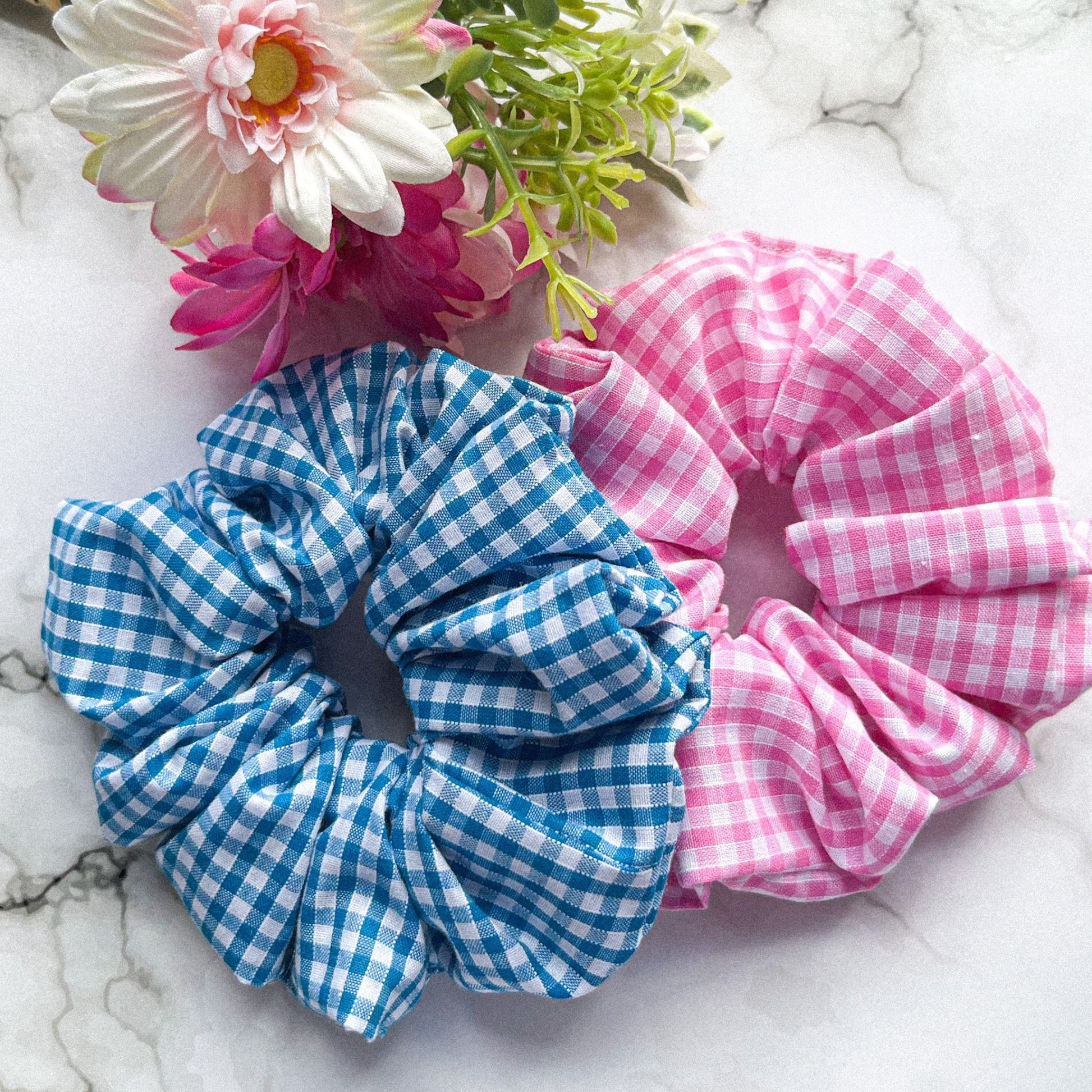 Styled overview of pink and blue gingham hair scrunchies cotton E for Eva