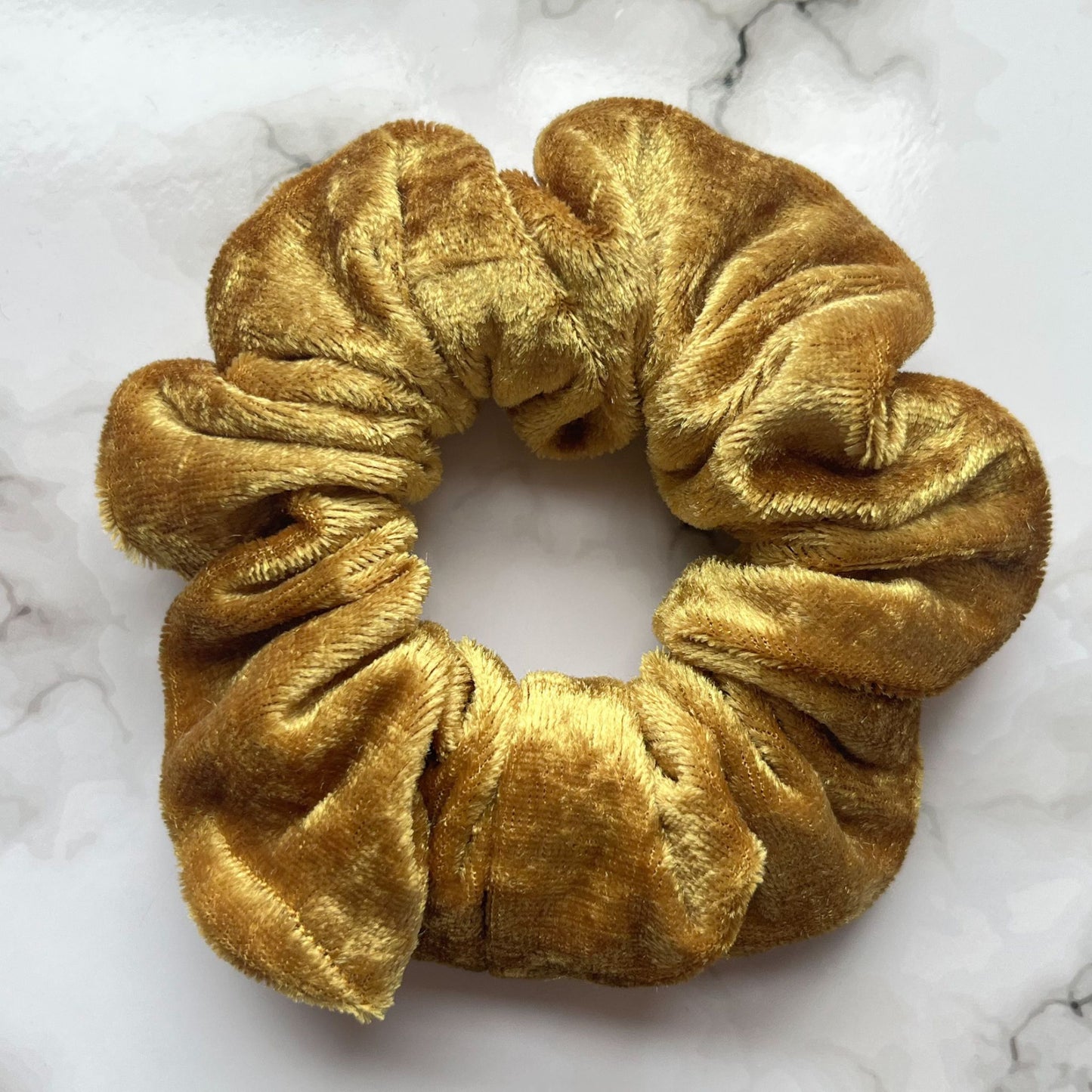 Close up of gold hair scrunchie velvet E for Eva