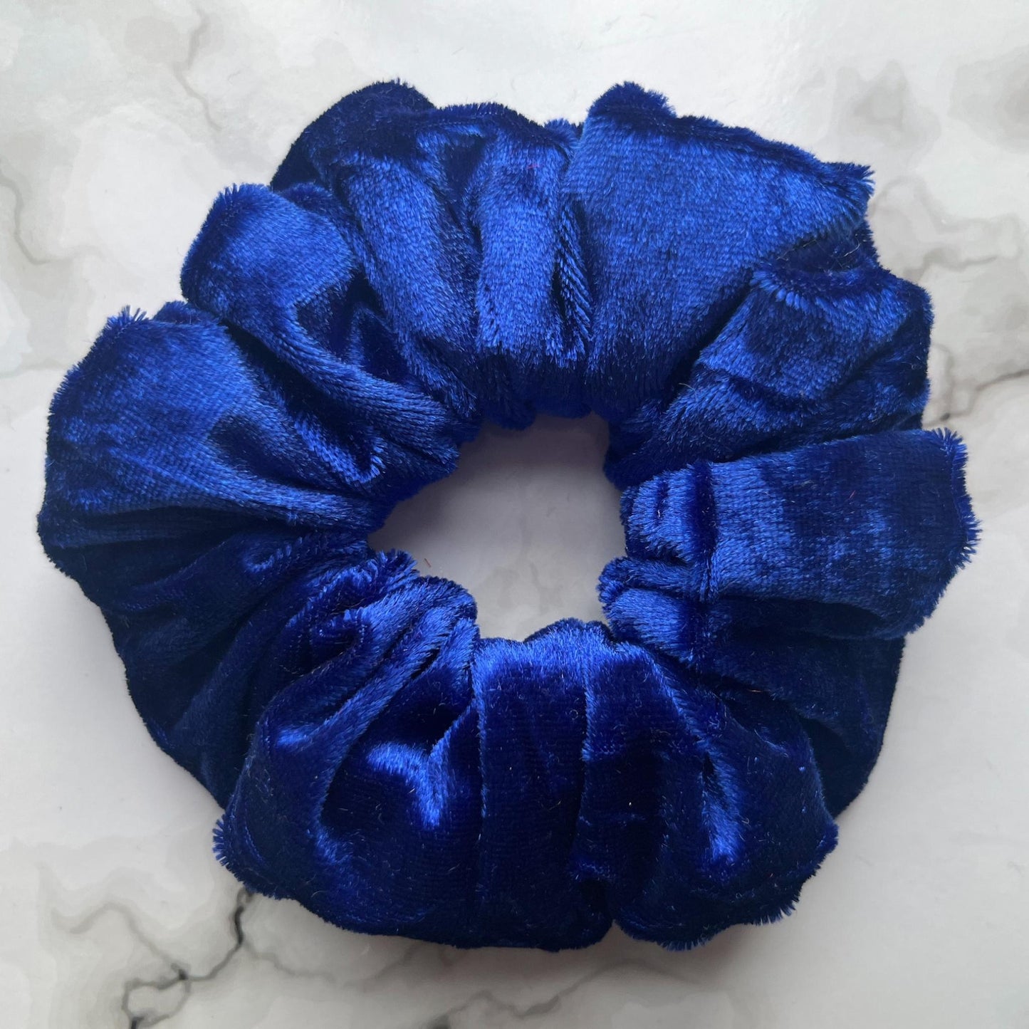 Close up of blue hair scrunchie velvet E for Eva