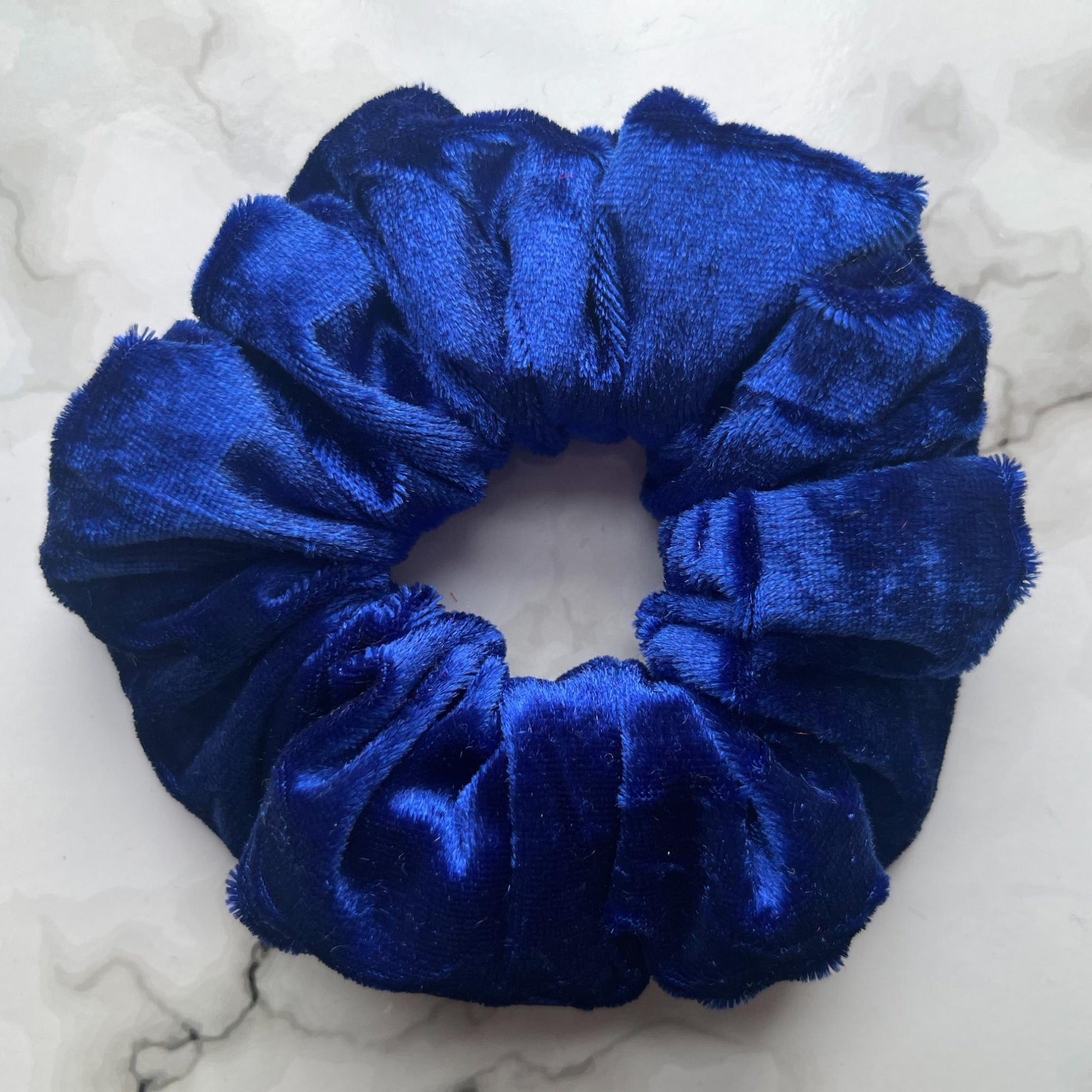 Close up of blue hair scrunchie velvet E for Eva
