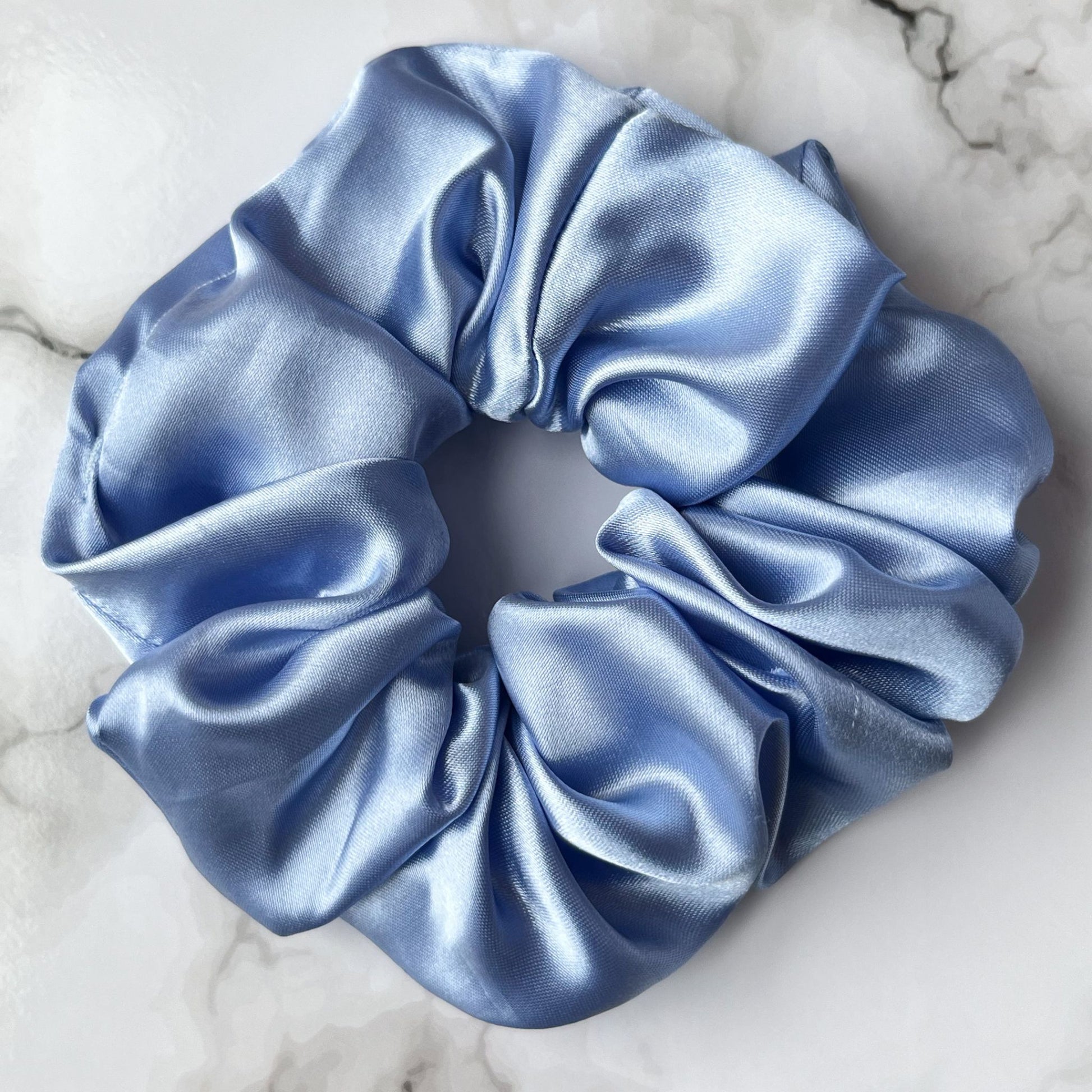 Close up of blue hair scrunchie satin E for Eva