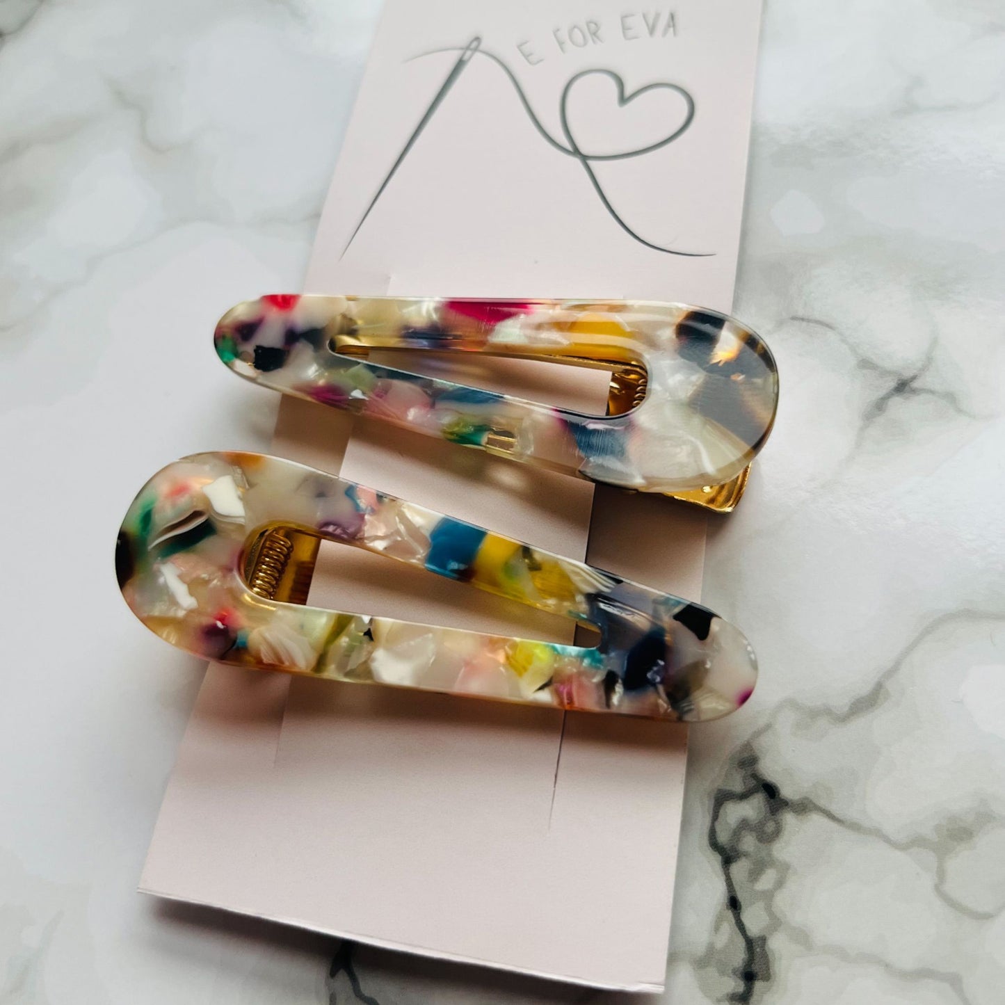Tagged view of white geometric hair clips E for Eva