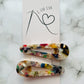 Tagged view of white geometric hair clips E for Eva