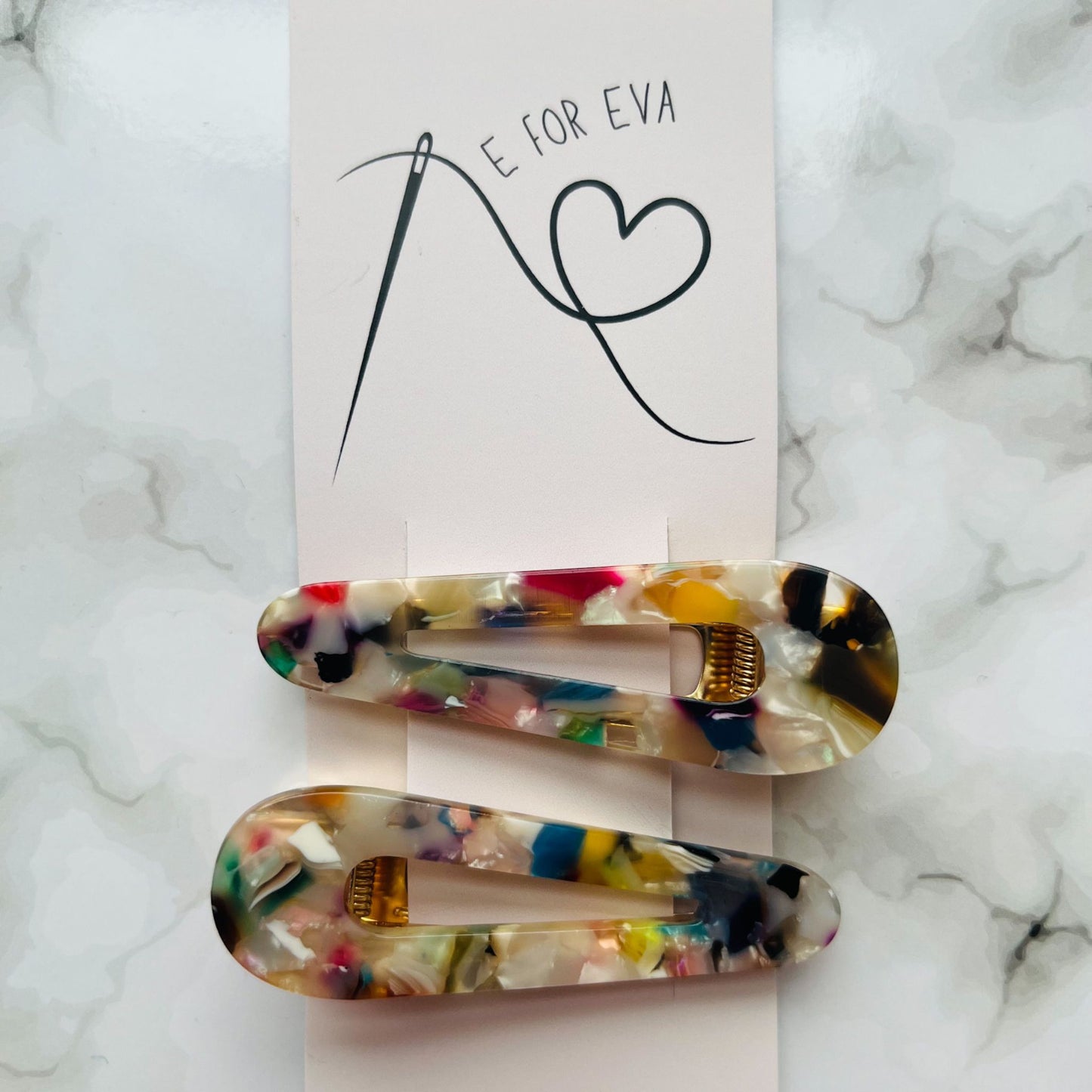 Tagged view of white geometric hair clips E for Eva