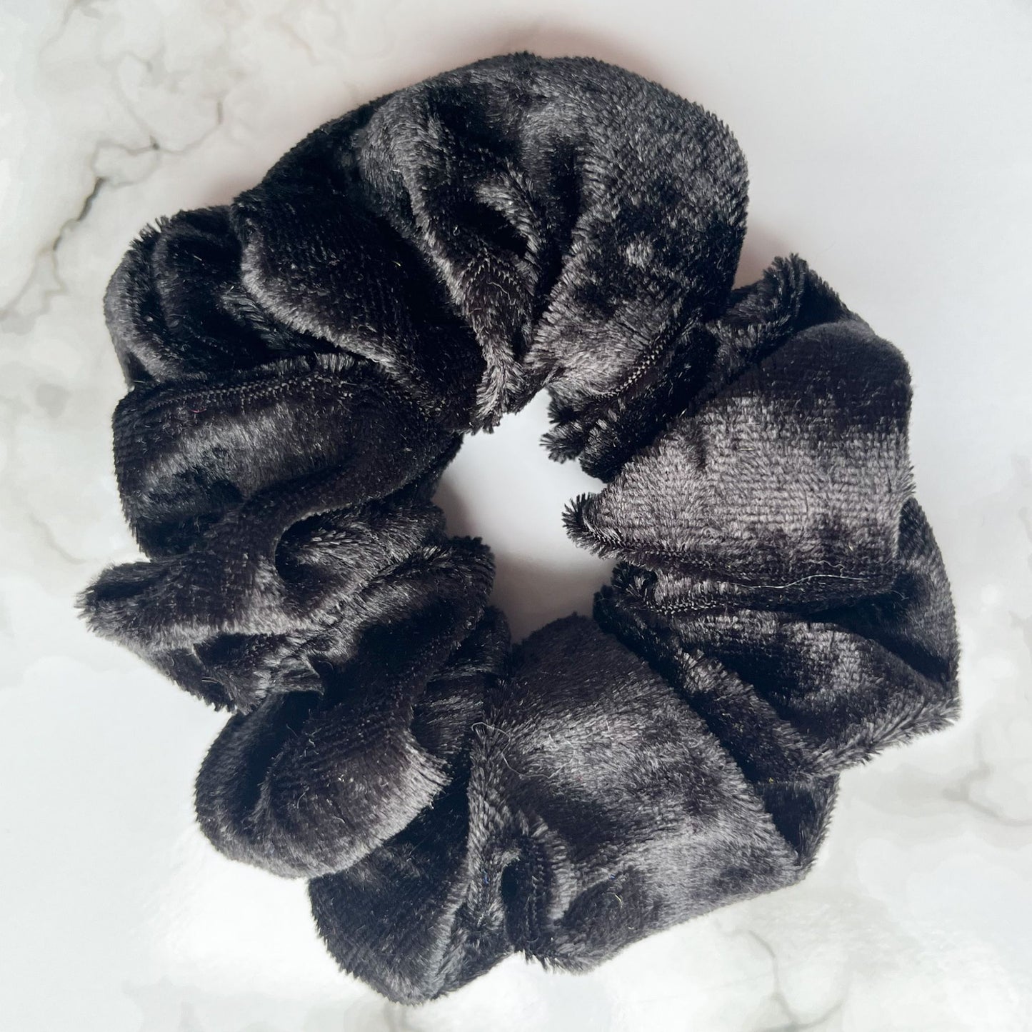 Close up of black velvet hair scrunchie E for Eva